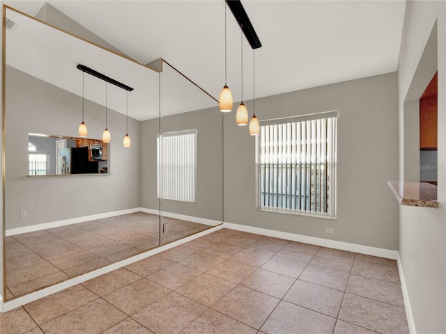 unfurnished dining area featuring a wealth of natural light, light tile patterned floors, and ceiling fan