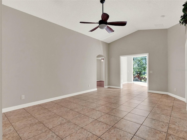 empty room with a textured ceiling, high vaulted ceiling, light tile patterned floors, and ceiling fan