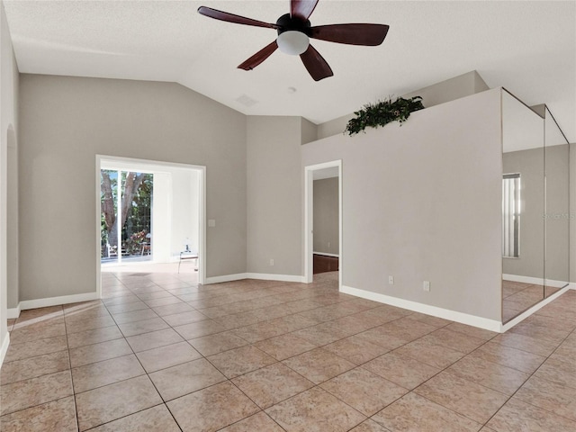 tiled spare room with vaulted ceiling, ceiling fan, and a textured ceiling