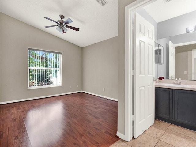 interior space with sink, vaulted ceiling, ceiling fan, and light hardwood / wood-style flooring