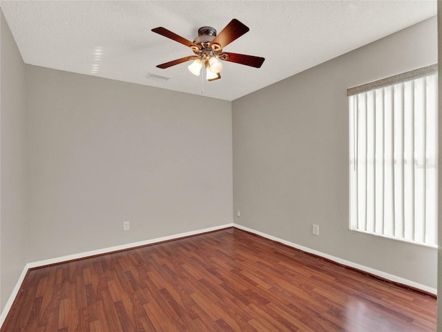 unfurnished room with ceiling fan, wood-type flooring, a textured ceiling, and a healthy amount of sunlight