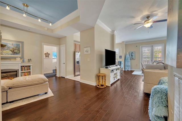 living room featuring ornamental molding, ceiling fan, dark hardwood / wood-style floors, and rail lighting