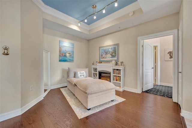 living area featuring dark hardwood / wood-style flooring, ornamental molding, and a raised ceiling