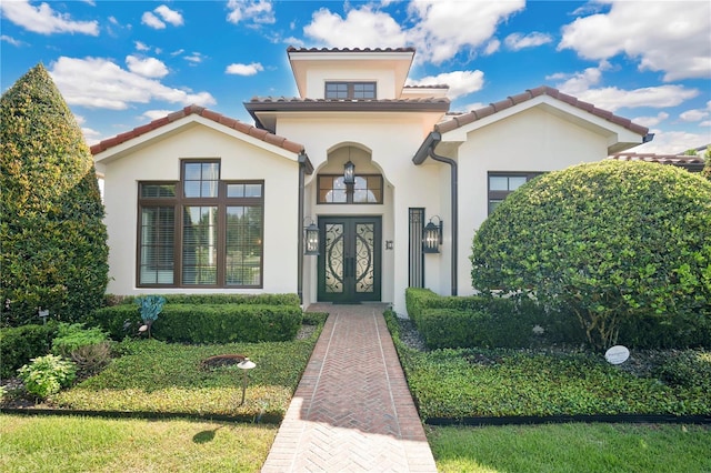 view of exterior entry featuring a lawn