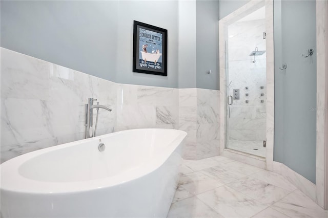 bathroom featuring shower with separate bathtub and tile walls