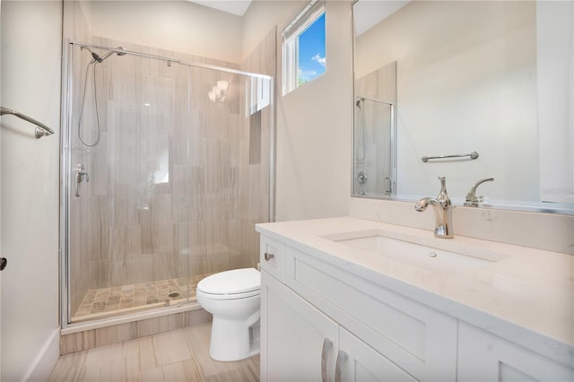 bathroom with a shower with door, vanity, and toilet