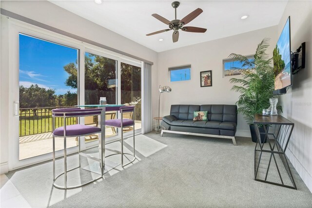 carpeted living room with ceiling fan