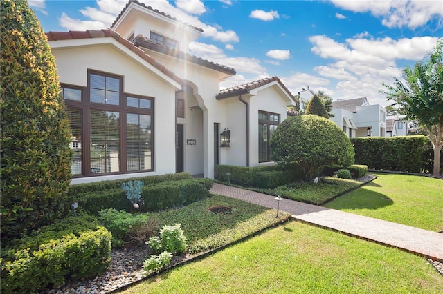 mediterranean / spanish home featuring a front yard