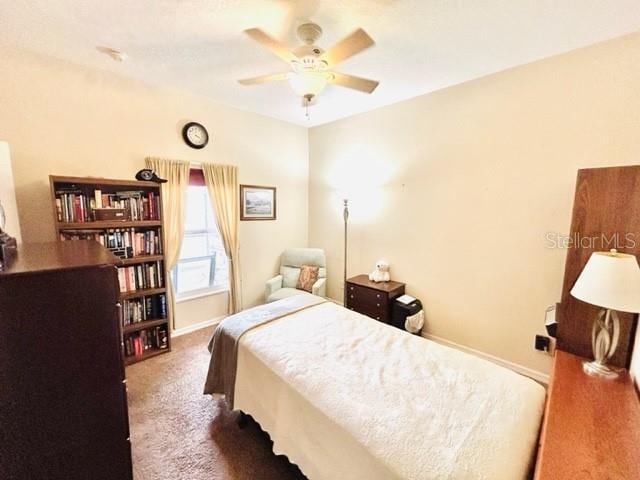 bedroom with ceiling fan and dark carpet