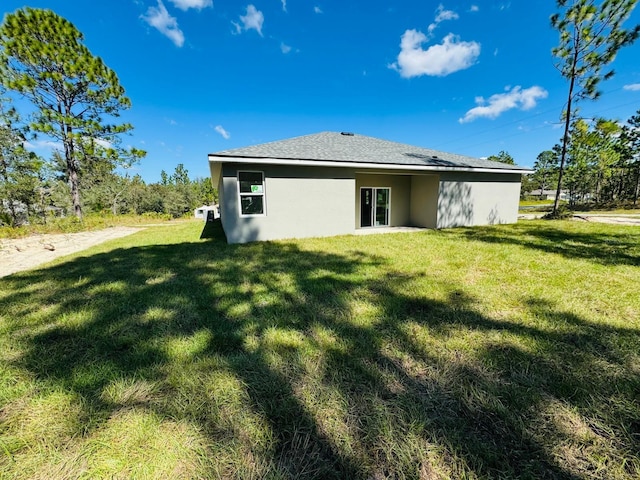 rear view of property featuring a lawn