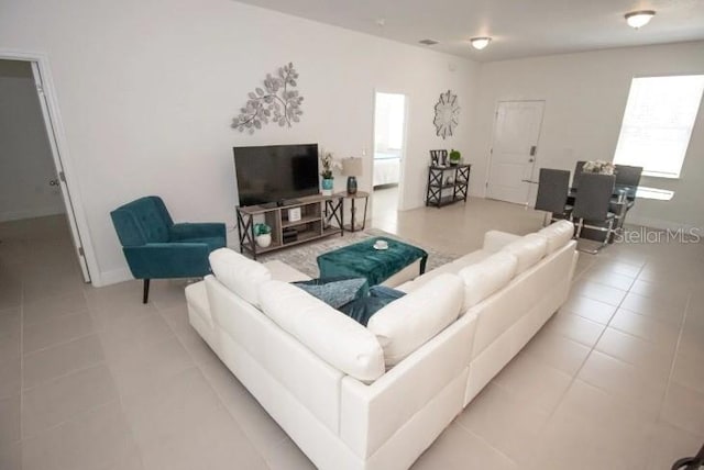 living room with a wealth of natural light and light tile patterned floors