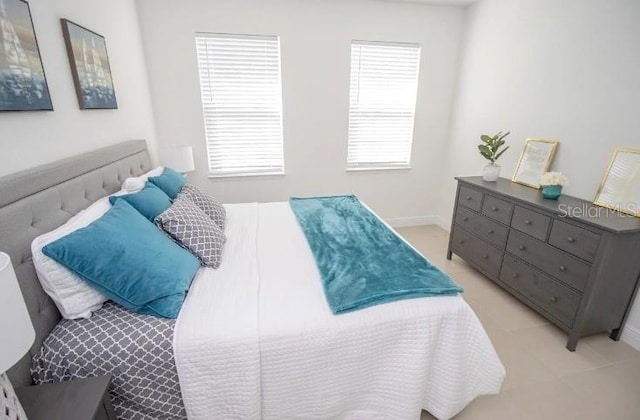 bedroom featuring multiple windows and light tile patterned floors