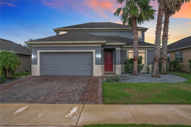 987 Nathan Ridge Rd, Clermont, FL 34715 - prairie-style house with stucco siding, decorative driveway, a garage, and a yard