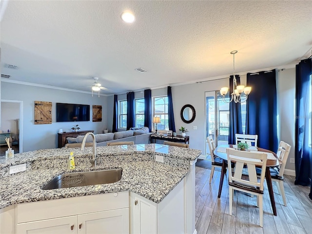 987 Nathan Ridge Rd, Clermont, FL 34715 - kitchen featuring a sink, a textured ceiling, a chandelier, a ceiling fan, and crown molding