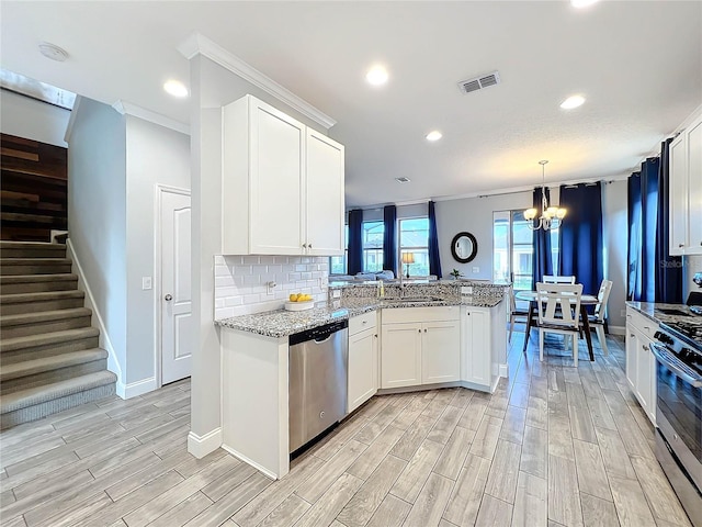 kitchen with stainless steel appliances, kitchen peninsula, decorative light fixtures, light hardwood / wood-style flooring, and white cabinets