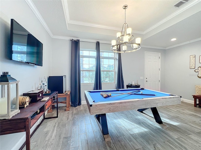 rec room featuring light hardwood / wood-style floors, pool table, a tray ceiling, a chandelier, and crown molding