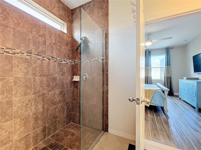 bathroom featuring a wealth of natural light, tiled shower, and ceiling fan