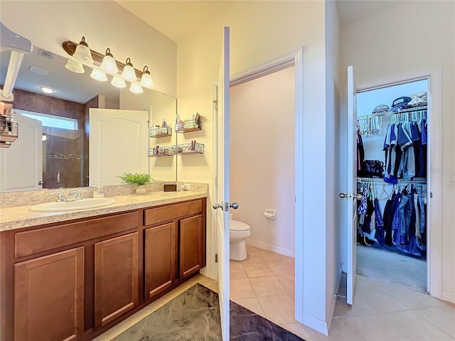 bathroom with toilet, vanity, tile patterned flooring, and a shower with door