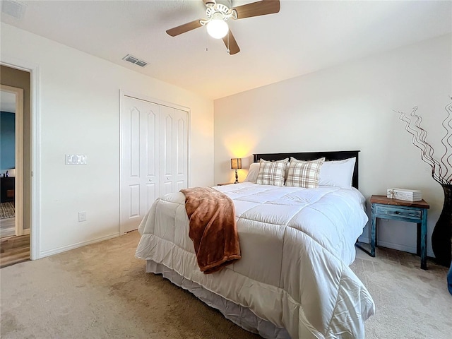 carpeted bedroom featuring ceiling fan and a closet