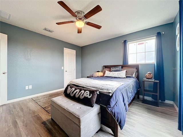 bedroom featuring a textured ceiling, light hardwood / wood-style floors, and ceiling fan