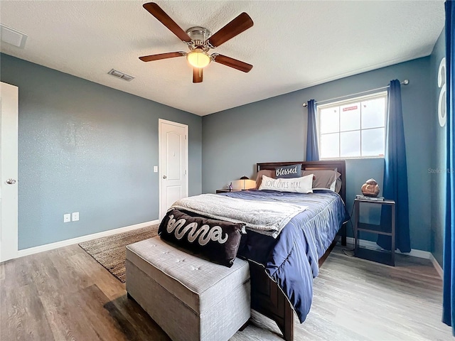 987 Nathan Ridge Rd, Clermont, FL 34715 - bedroom with light wood-style floors, baseboards, a ceiling fan, and a textured ceiling