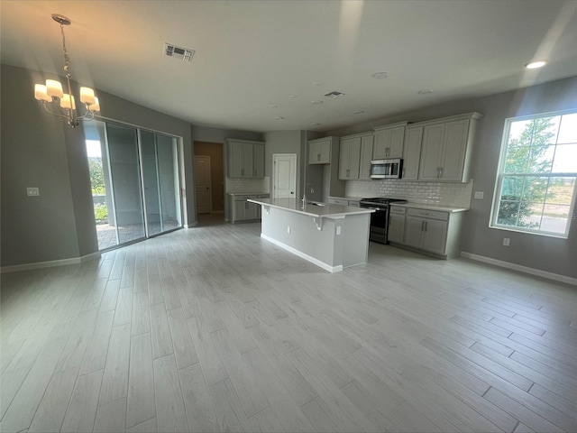 kitchen featuring a sink, a chandelier, stainless steel appliances, visible vents, and baseboards