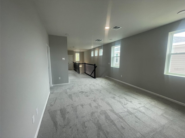 spare room featuring visible vents, baseboards, recessed lighting, and light carpet
