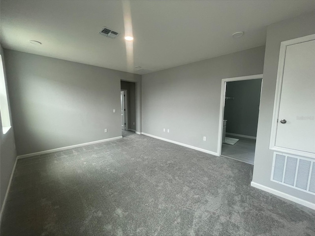 unfurnished bedroom featuring visible vents, connected bathroom, baseboards, and carpet floors