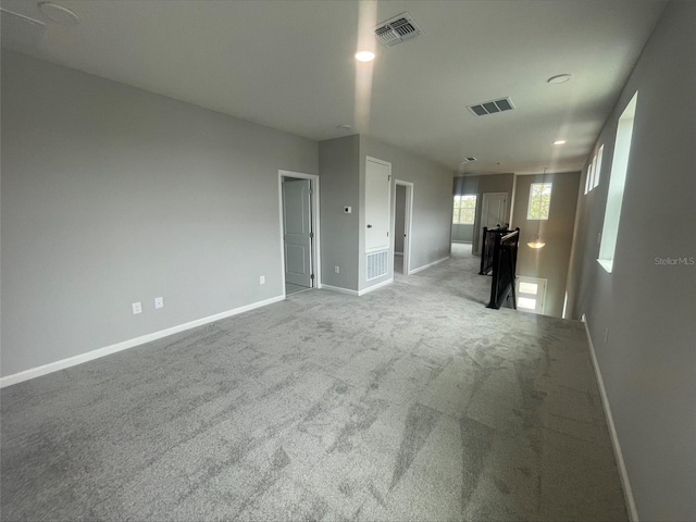 unfurnished room with baseboards, visible vents, carpet, and recessed lighting