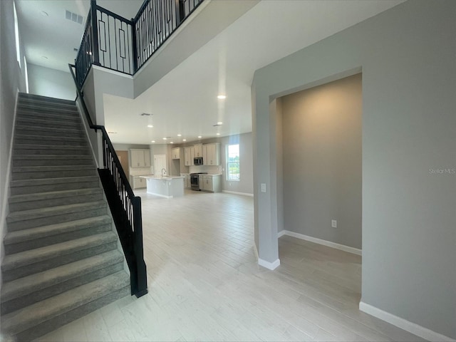 staircase with baseboards, visible vents, wood finished floors, and recessed lighting