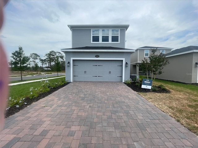 view of front facade featuring stucco siding, decorative driveway, a front yard, and a garage