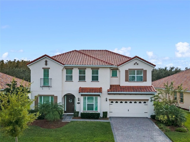 mediterranean / spanish home with a garage and a front yard