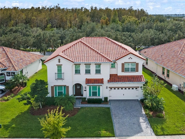 mediterranean / spanish-style home featuring a garage and a front yard