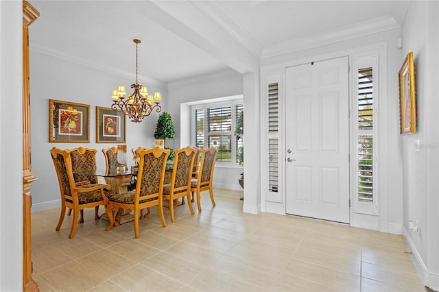 tiled entryway with ornamental molding and a chandelier