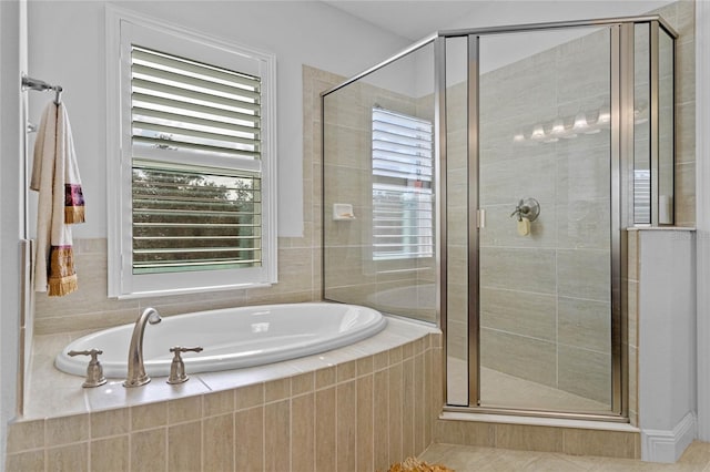 bathroom with shower with separate bathtub and plenty of natural light