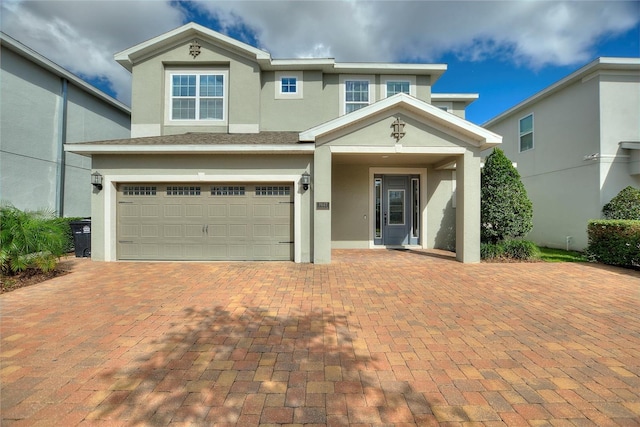 view of front of home featuring a garage, driveway, and stucco siding