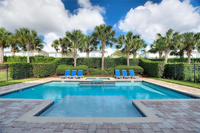 view of pool featuring a patio and an in ground hot tub