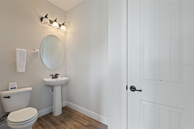 bathroom with toilet and hardwood / wood-style floors