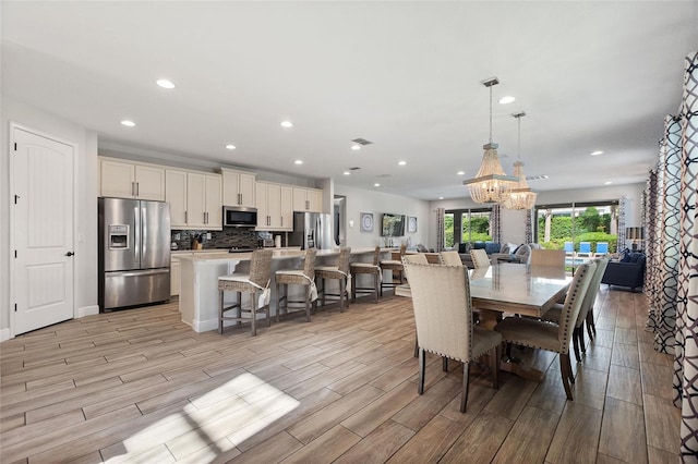 dining area featuring a notable chandelier and light hardwood / wood-style floors