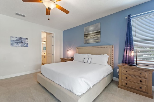 carpeted bedroom featuring connected bathroom, a textured ceiling, and ceiling fan