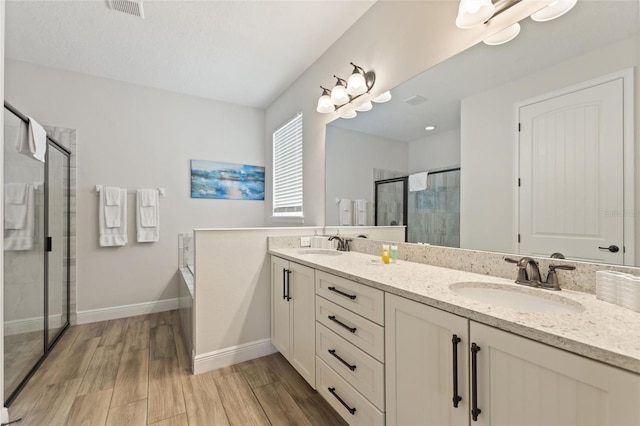 bathroom with independent shower and bath, vanity, and hardwood / wood-style floors