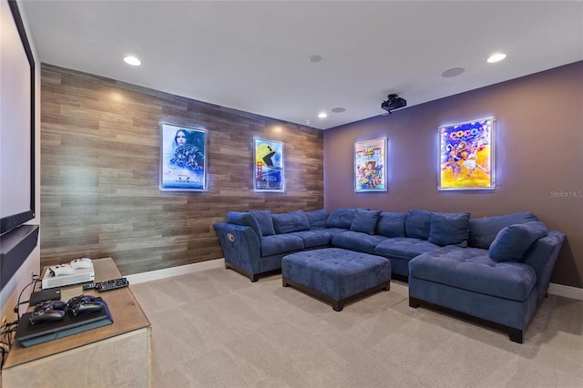 carpeted home theater room featuring wooden walls