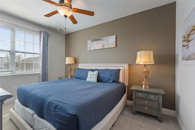 bedroom with a textured ceiling, light carpet, and ceiling fan