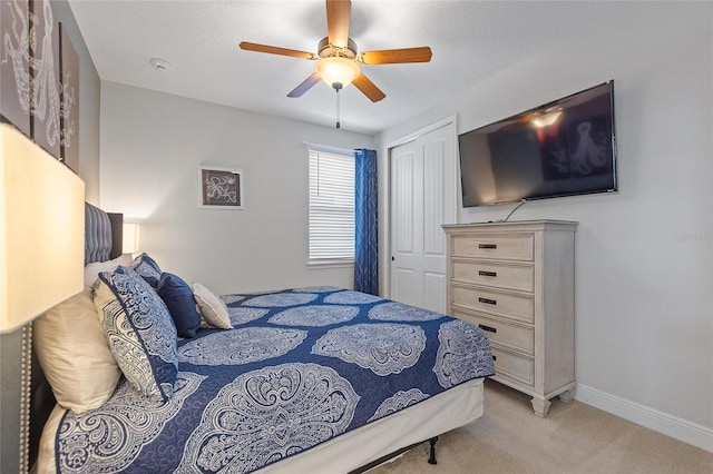 carpeted bedroom featuring a closet and ceiling fan