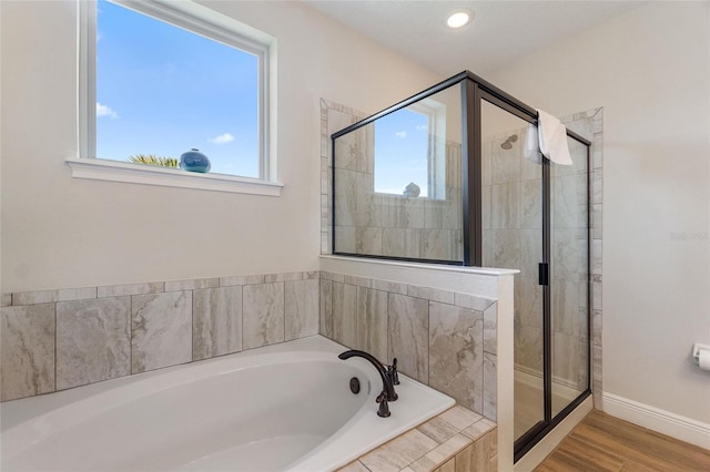 bathroom featuring plus walk in shower and hardwood / wood-style flooring