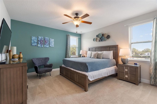 carpeted bedroom with ceiling fan and a textured ceiling