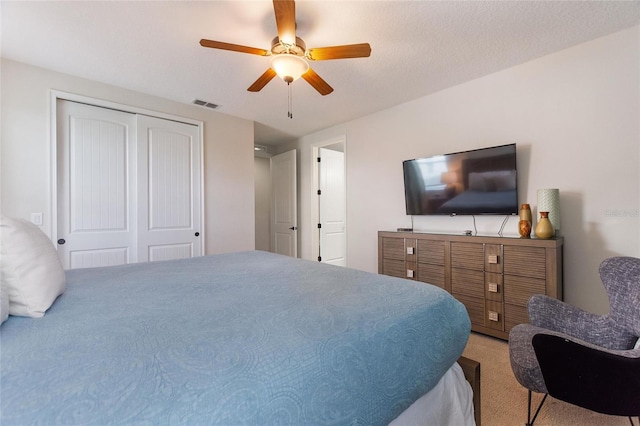 bedroom featuring ceiling fan, a textured ceiling, a closet, and carpet floors