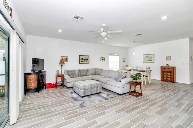 living room featuring ceiling fan and light hardwood / wood-style floors