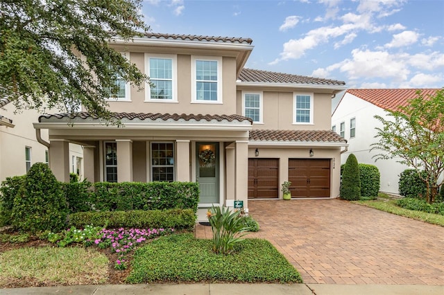 mediterranean / spanish house featuring a garage and a porch