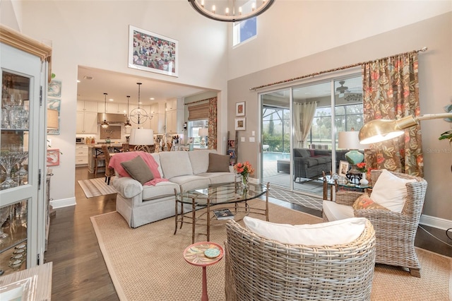 living room with hardwood / wood-style floors, a high ceiling, and an inviting chandelier